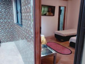 a room with a glass door leading to a bedroom at pousada benção in Aparecida