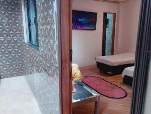 a room with a room with a bed and a table at pousada benção in Aparecida