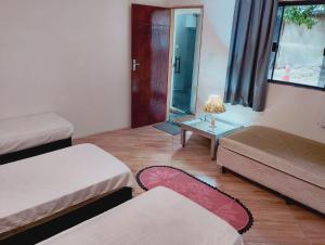 a small room with two beds and a table at pousada benção in Aparecida