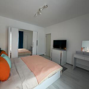 a bedroom with a bed and a flat screen tv at Otopeni Studio C2 3 Airport Therme in Otopeni