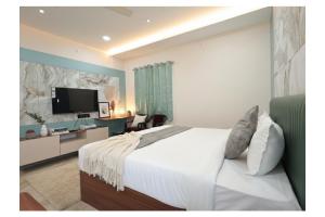 a bedroom with a large white bed and a television at Hotel Anmol One in Indore +12 photos