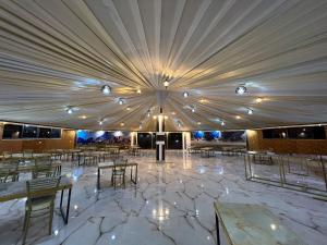 a large tent with tables and chairs and lights at Skylight Wadi Rum Camp in Disah