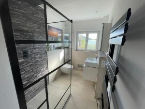 a bathroom with a sink and a toilet and a window at Komfort-Fewo mit Infrarotsauna & WLAN nahe Sorpesee - Haus am Krähenbach - Steinert in Sundern