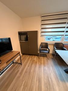 a living room with a television and a table and chairs at WorkHome A2 zu 3 in Lünen +1 photo