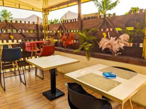 a restaurant with tables and chairs and plants at Appart M'Rode Baguida in Lomé
