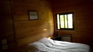 a bedroom with a bed and a window at Le Chalet de Seb in Ingouville +2 photos