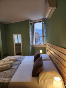 a large bed in a green room with a window at Bellagio Love apartment Pool Near lake Free parking in Bellagio +32 photos