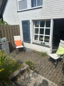 two chairs sitting on a patio in front of a house at Gemütlichkeit im Grünen in Warendorf
