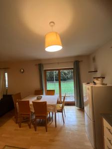 a kitchen and dining room with a table and a refrigerator at Kildare cozy home in Kildare
