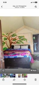a bedroom with a bed with a tree painted on it at Classic hostel in Katra