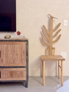 a wooden chair sitting next to a tv at Diamantino Residence - Barro in Mucugê