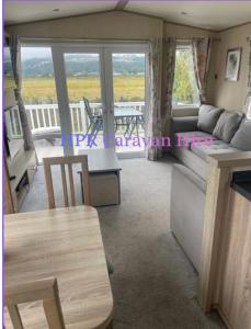 a living room with a couch and a table at 3 bedroom, 2 bathroom caravan Presthaven Beach Resort in Talacre