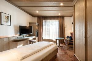 a hotel room with a bed and a television at Hotel Promenade in Bad Füssing