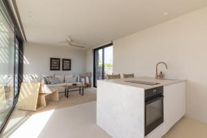 a kitchen and living room with white walls and a large window at Gara Suite Boutique Design Villa Private Pool in Lajares