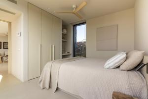 a white bedroom with a bed and a window at Gara Suite Boutique Design Villa Private Pool in Lajares