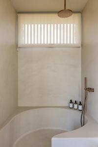 a white bath tub in a bathroom with a window at Gara Suite Boutique Design Villa Private Pool in Lajares +16 photos