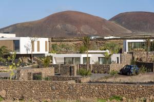 a house with a mountain in the background at Gara Suite Boutique Design Villa Private Pool in Lajares