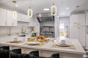 a kitchen with white cabinets and a large island with food on it at Sleeps36 2Homes 12BR Heated Pool Spa Pickleball 14 Parking in Clearwater +37 photos
