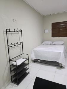 a bedroom with a bed and a shelf next to it at Hotel Fazenda Arena Green in Cajazeiras