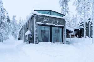 a building covered in snow in the woods at Levin Primus - Your Glass-Roof Gateway to Laplands Magic in Levi