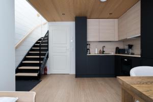 a kitchen with black cabinets and a spiral staircase at Levin Primus - Your Glass-Roof Gateway to Laplands Magic in Levi