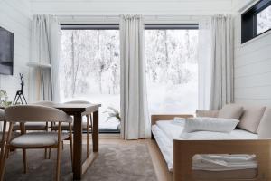 a living room with a couch and a table and a window at Levin Primus - Your Glass-Roof Gateway to Laplands Magic in Levi
