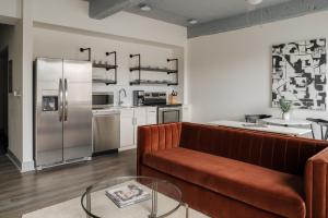 a living room with a couch and a refrigerator at Kasa Capitol Hill Downtown Nashville in Nashville