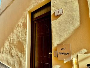 a door to a building with a sign next to it at Affittacamere Ca Stella Antares a La Morra centro in La Morra +3 photos