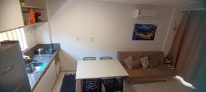 a kitchen with a couch and a table in a room at Aconchego da Jandaia in Imbassai