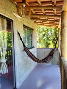 a hammock on the porch of a house at Vila Mukaú in Porto Seguro