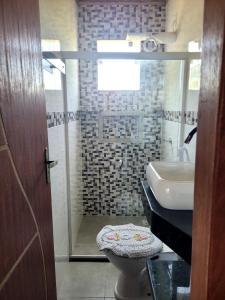 a bathroom with a shower and a toilet and a sink at Vila Mukaú in Porto Seguro