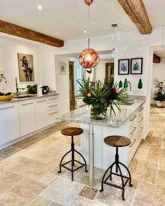 a kitchen with a counter with stools and a island at La Villa au Patio Suspendu by GC - Clim - Wifi in Sérignan