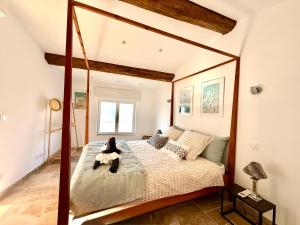 a bedroom with a bed with a teddy bear sitting on it at La Villa au Patio Suspendu by GC - Clim - Wifi in Sérignan