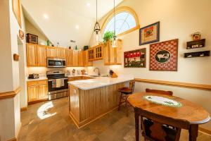 a kitchen with wooden cabinets and a wooden table at Doggone Perfect - Village at Nags Head, Soundfront, Golf Course View, Pool, Hot Tub, Pets OK, Flex Stays in Nags Head