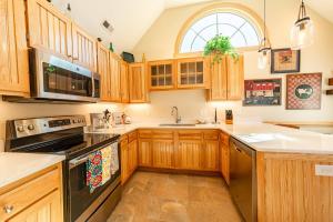a kitchen with wooden cabinets and a large window at Doggone Perfect - Village at Nags Head, Soundfront, Golf Course View, Pool, Hot Tub, Pets OK, Flex Stays in Nags Head