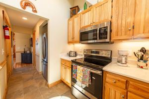 a kitchen with a stove and a microwave at Doggone Perfect - Village at Nags Head, Soundfront, Golf Course View, Pool, Hot Tub, Pets OK, Flex Stays in Nags Head