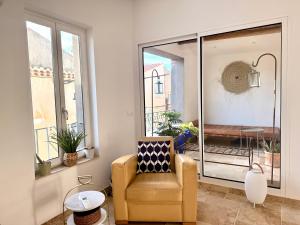 a living room with a chair and a window at La Villa au Patio Suspendu by GC - Clim - Wifi in Sérignan +35 photos