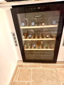 a microwave oven with wine bottles in it at La Villa au Patio Suspendu by GC - Clim - Wifi in Sérignan
