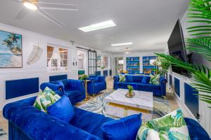 a living room with blue couches and a table at Sleeps36 2Homes 12BR Heated Pool Spa Pickleball 14 Parking in Clearwater