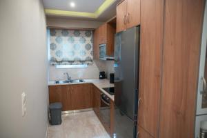 a kitchen with wooden cabinets and a stainless steel refrigerator at Efraim Oasis in Kos
