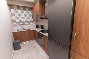 a small kitchen with a refrigerator and a sink at Efraim Oasis in Kos +26 photos