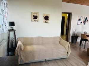 a living room with a couch and a clock on the wall at Elaia Horizon Makri in Alexandroupoli