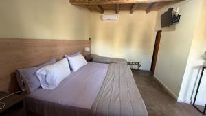 a bedroom with a bed with white sheets and pillows at Posada Solar de las Piedras in Fiambalá