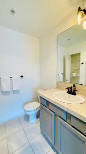 a bathroom with a sink and a toilet and a mirror at 2B2B apartment with stunning window -7min to Dome in Tacoma