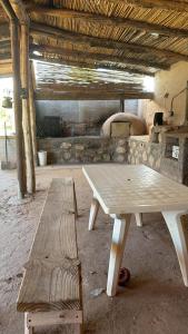 two wooden tables and a bench in a room at Posada Solar de las Piedras in Fiambalá