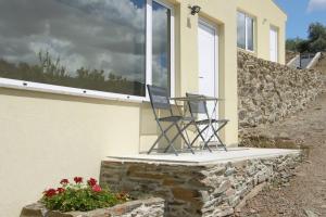 a black chair sitting on a porch next to a window at EiraDouro - Casa Oliveira in Mós