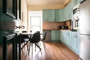a kitchen with blue cabinets and a table and chairs at Kylemore house boutique apartments - Diamond Lounge in Kylemore