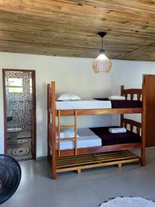 a room with two bunk beds and a ceiling at Vila Mukaú in Porto Seguro