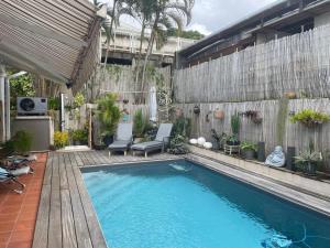 a swimming pool in a backyard with chairs and a fence at Casefilo in Sainte-Luce