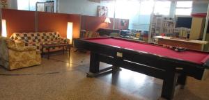 a living room with a pool table and chairs at Auberge La Petite École de Forillon in Gaspé